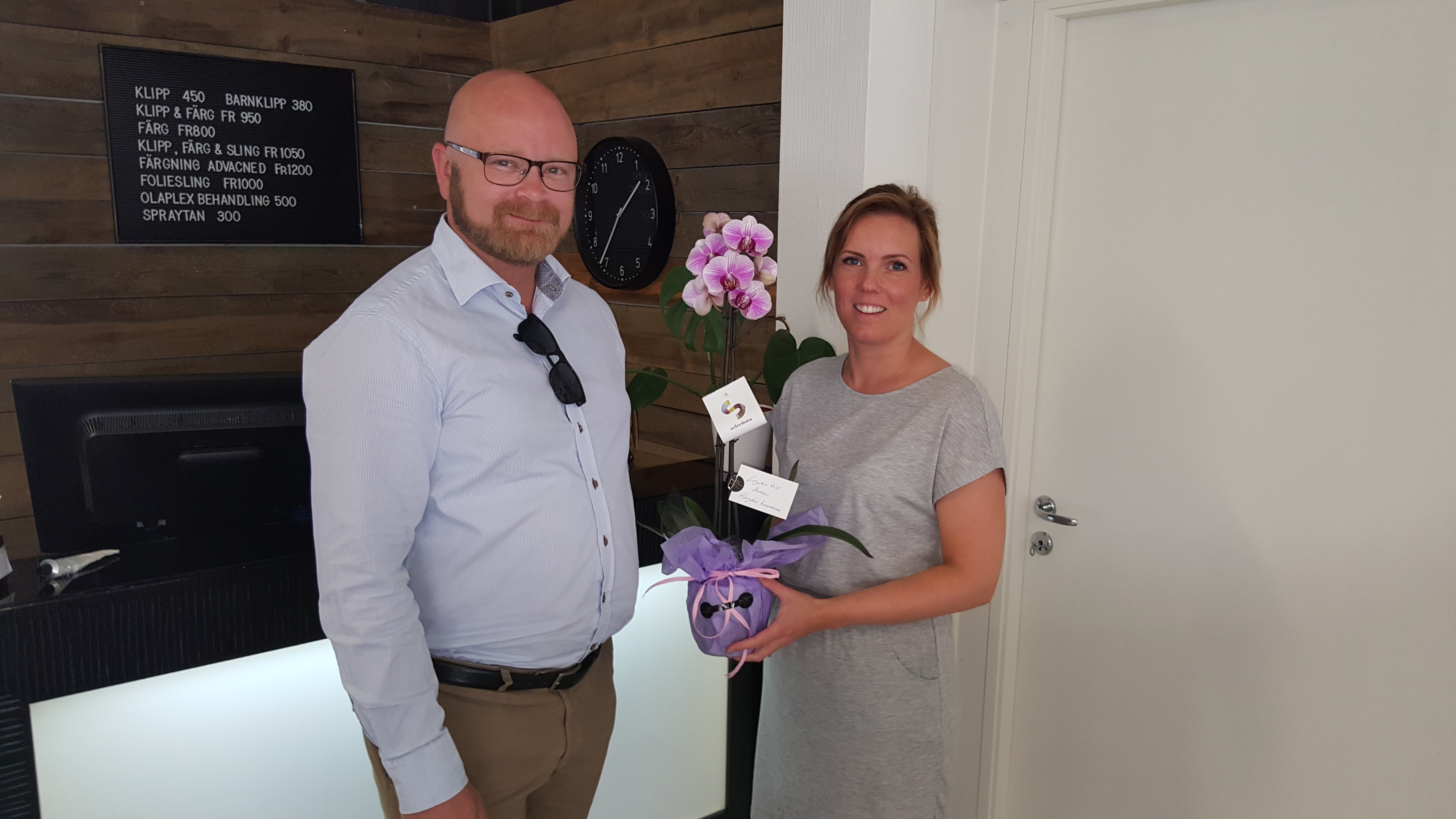 Lars överlämnar en blomma till en av företagets ägare